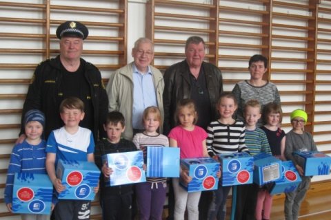 Kiwanismenn færa nemendum í 1. bekk hjólahjálma.